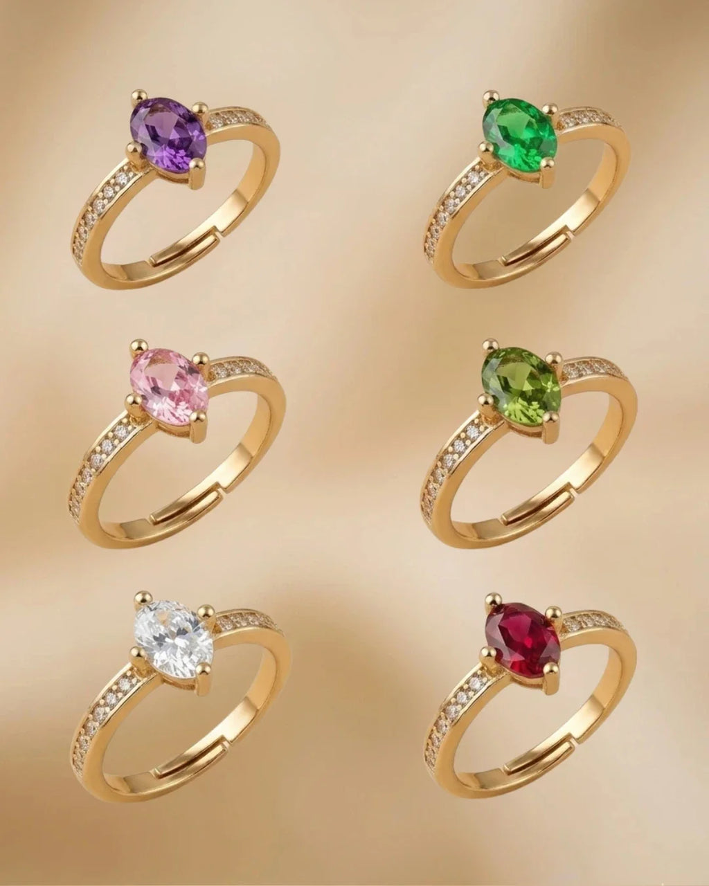 Set of gold rings with colored gemstones on a beige background