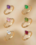 Set of gold rings with colored gemstones on a beige background