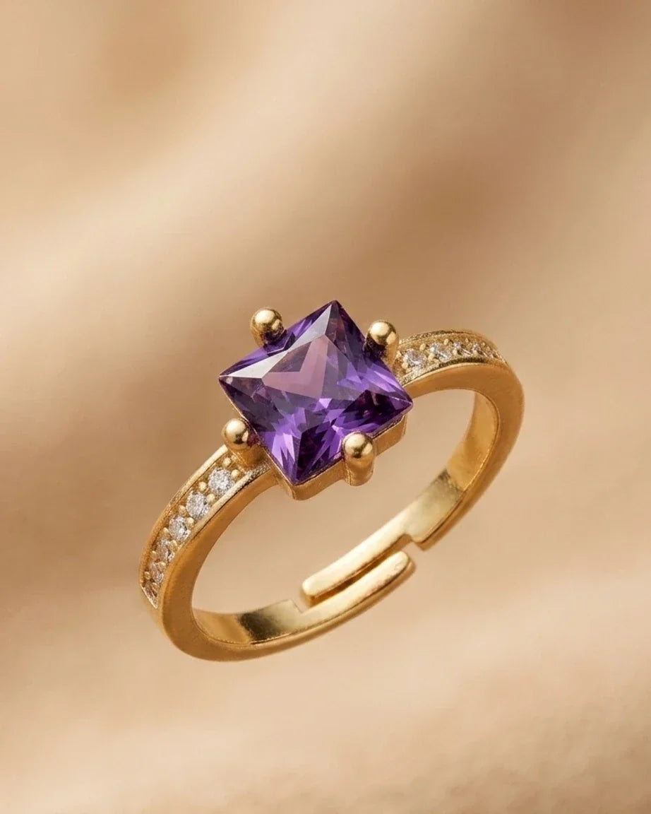 Gold ring with a purple gemstone on a gold background